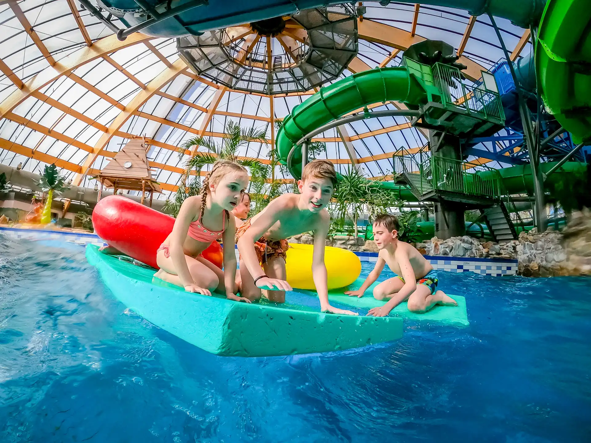 Kinderen spelen op drijvende matten in het subtropisch zwembad van Landal De Lommerbergen.